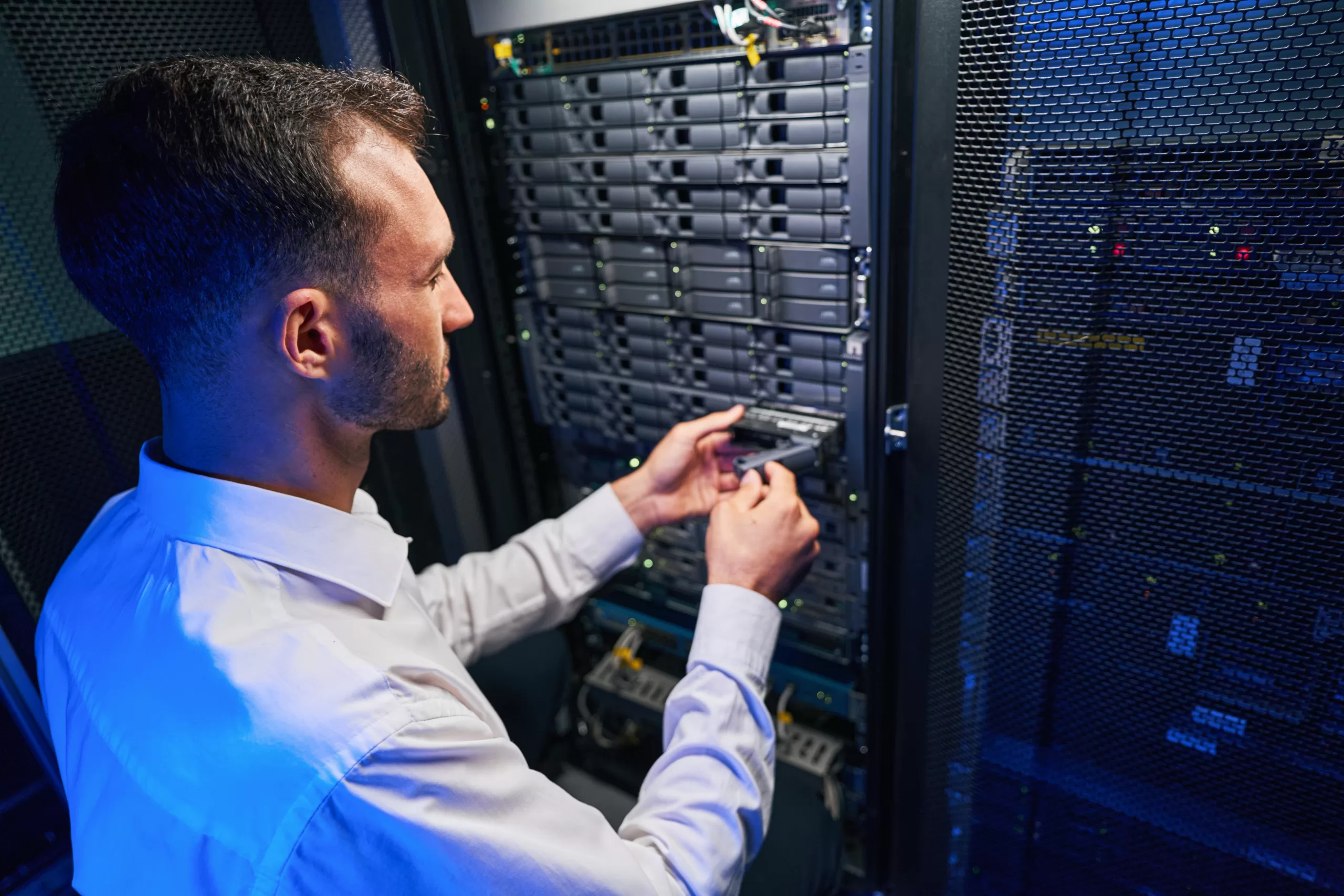 Caucasian network engineer in white shirt is finding and troubleshooting server in tech place